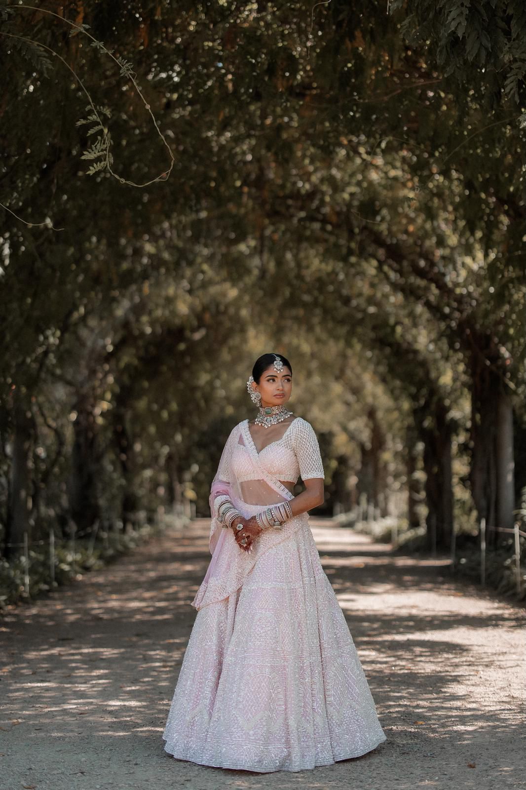 Bride in pastel lehenga with polki kundan bridal set in tree alley