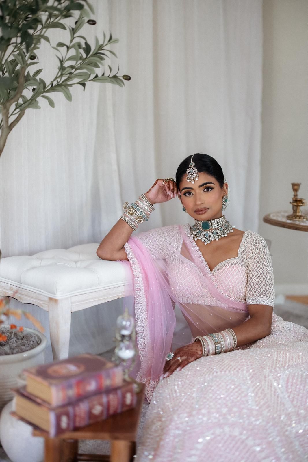 Bride in pink and white lehenga with emerald kundan jewellery set